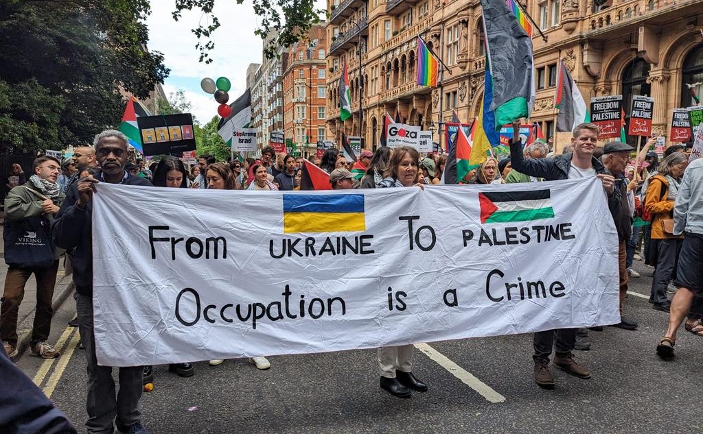 banner met “from ukraine to palestine occupation is a crime”